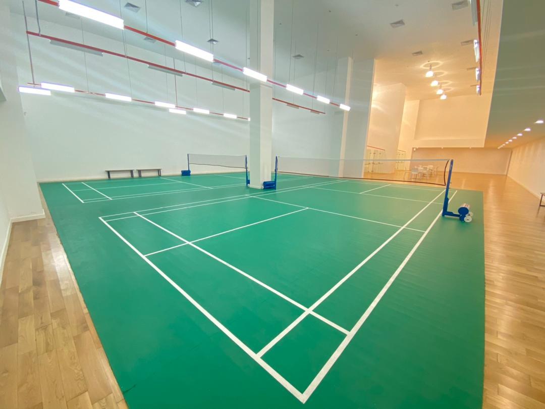 Indoor badminton court with marked green flooring