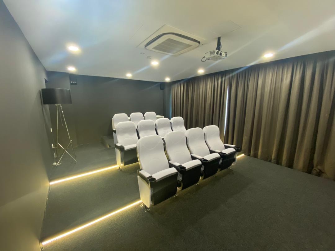 Private screening room with tiered seating and blackout curtains