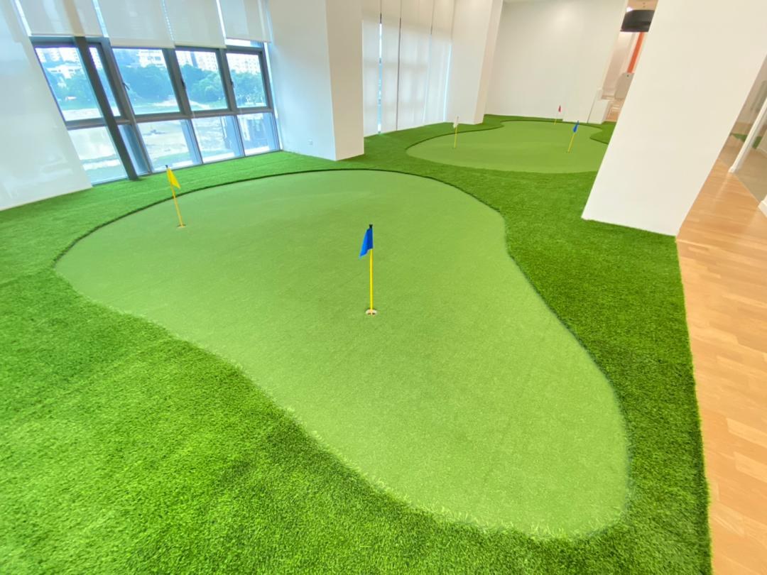 Indoor putting green with contoured artificial turf and a flag