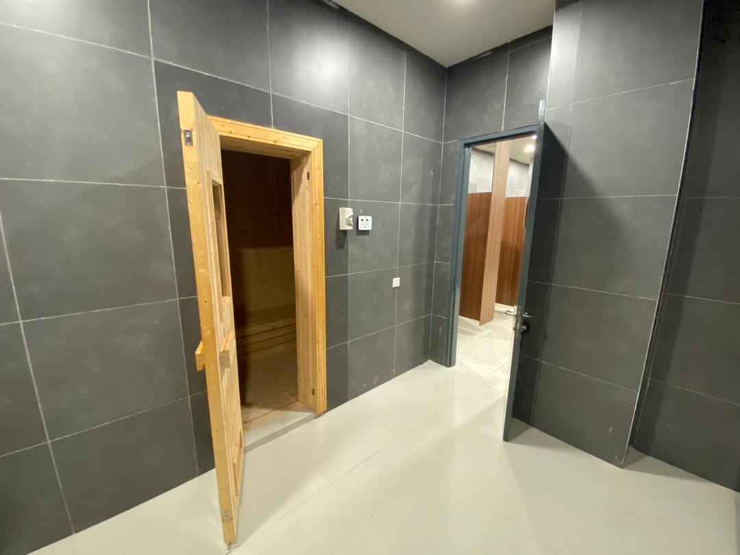 Sauna room with timber door set within tiled changing facilities